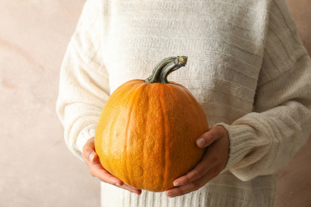 istock Young woman holding pumpkin on brown background, copy space 1171648209
