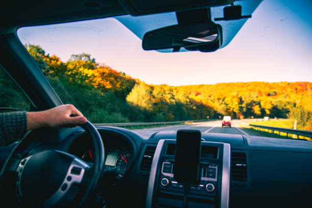 istock man hands on steering wheel riding by autumn speedway fall season 1171650333