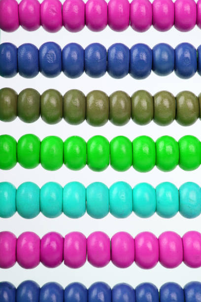 Heart of handicraft beads with variagated beads on yellow background with copyspace