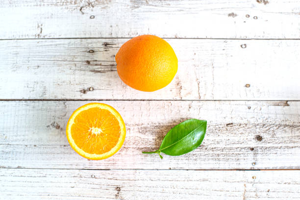 istock orange and slices on white wooden background 1171652195