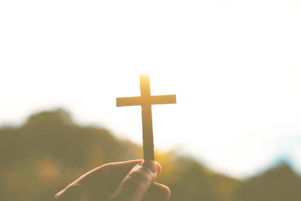 istock Silhouette of human hands holding a cross holy 1171652294