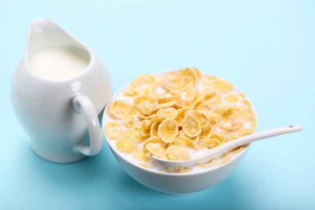 istock Corn flakes in bowl with milk and spoon on blue background 1171652299