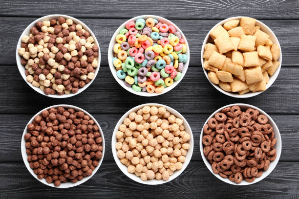 istock Various corn flakes in bowls on black wooden table 1171652380