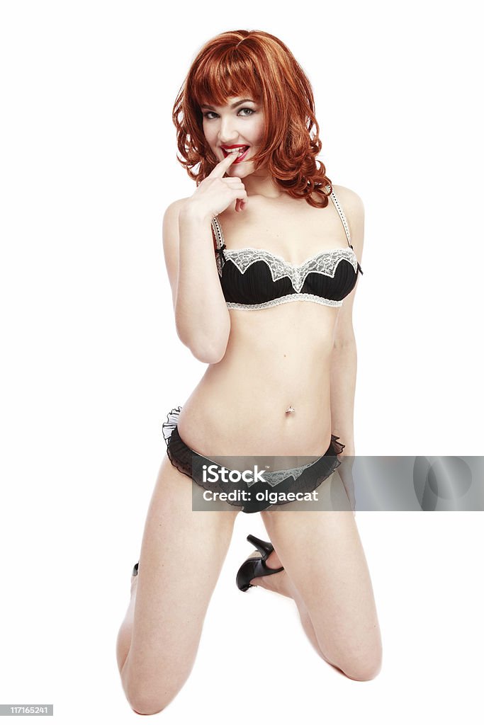 Flirting redhead Pretty slim red-haired girl in black sexy lingerie standing on her knees Adult Stock Photo