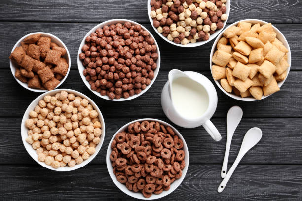istock Various corn flakes with milk in jar and spoons on black wooden table 1171652638