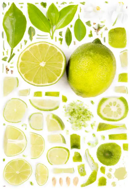 Large collection of lime fruit pieces, slices and leaves isolated on white background. Top view. Seamless abstract pattern.