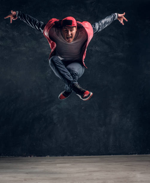 istock Emotional stylish dressed guy performing break dance jumping. 1171654581