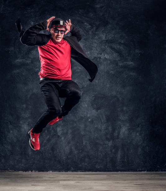 istock Emotional stylish dressed guy performing break dance jumping. 1171654595