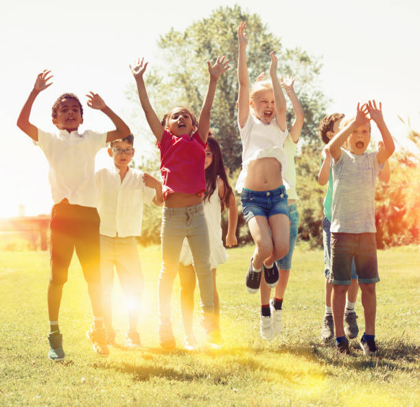 istock Friendly kids jumping together in park on summer 1171655832
