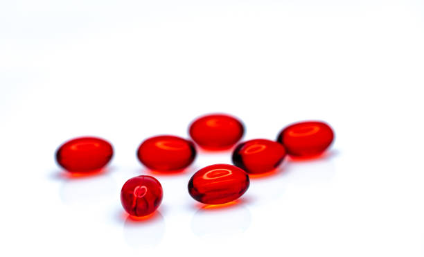 красный мягкий гель капсулы таблетки изолированы на белом фоне. куча красной мягкой желатиновой капсулы. витамины и пищевые добавки концеп - anti aging pill capsule vitamin pill стоковые фото и изображения