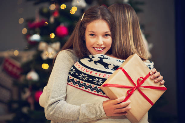 istock Mother and daughter with presents over Christmas tree 1171657404