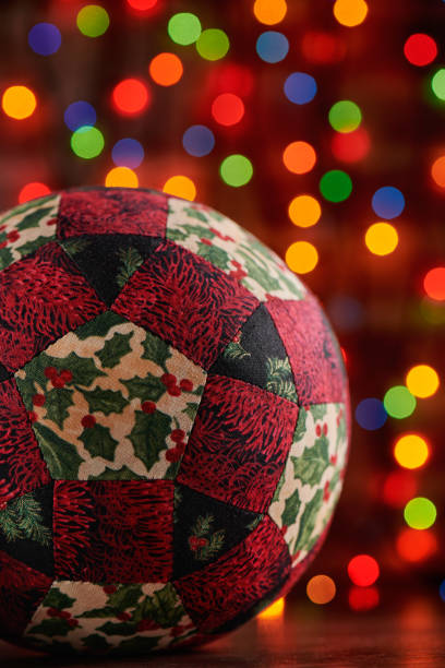 christmas decoration ball sewn from pieces of fabrics on dark colorful bokeh background - christmas quilt craft patchwork imagens e fotografias de stock