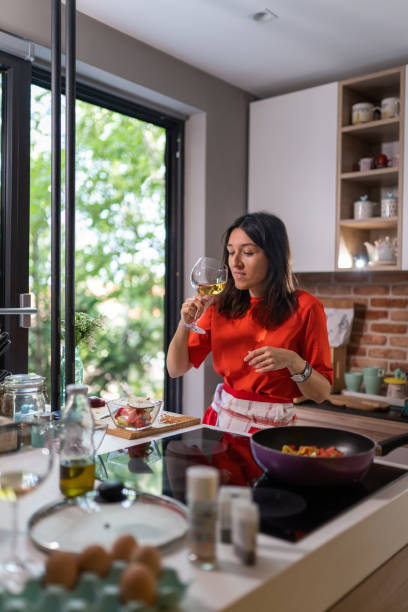 istock Young woman making a lunch, and tasting wine 1171662794