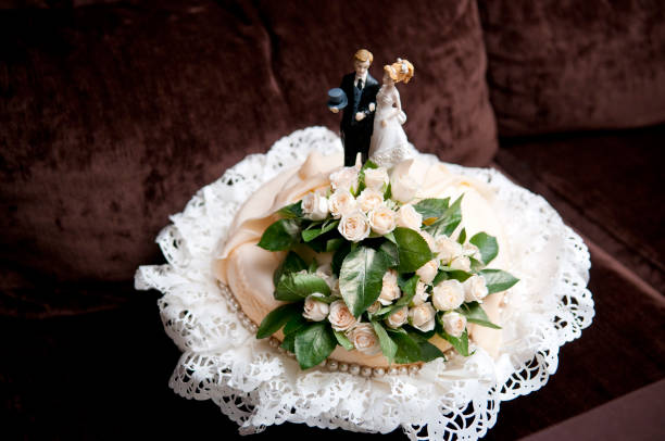 small wedding cake with figures of the bride and groom on top small wedding cake with figures of the bride and groom wedding cake close up macro stock pictures, royalty-free photos & images