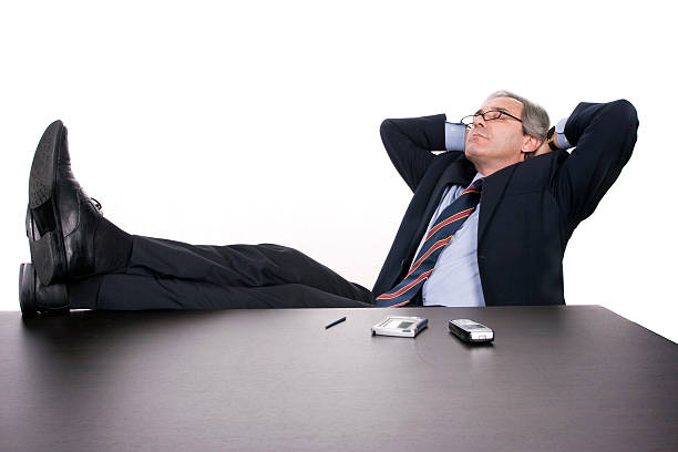 Successfull businessman relaxing over his desk stock photo