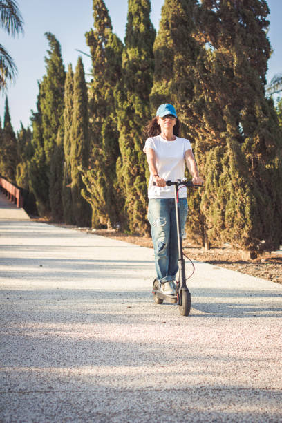 istock Woman, dressed in broken jeans, riding electric kick scooter 1171667385