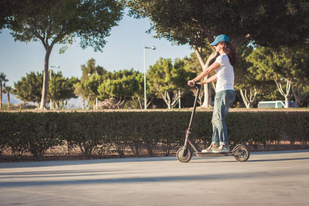 istock Woman, dressed in broken jeans, riding electric kick scooter 1171668899