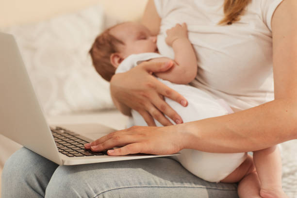 istock Young mother feeding baby with breast milk  and working on computer on her laps 1171670169