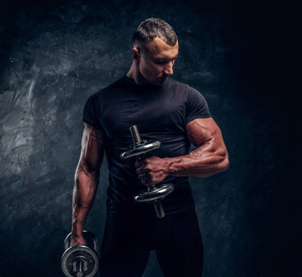 Muscular attractive bodybuilder lifting a barbell stock photo