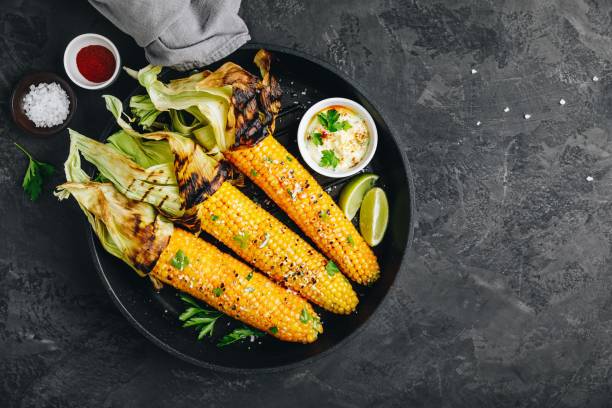 Roasted or grilled sweet corn cobs with garlic butter and lime. stock photo