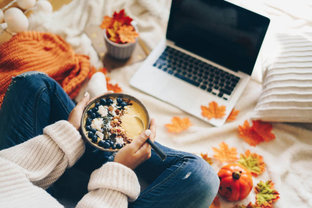 istock Woman having healthy breakfast and using laptop - Autumn concept 1171675747