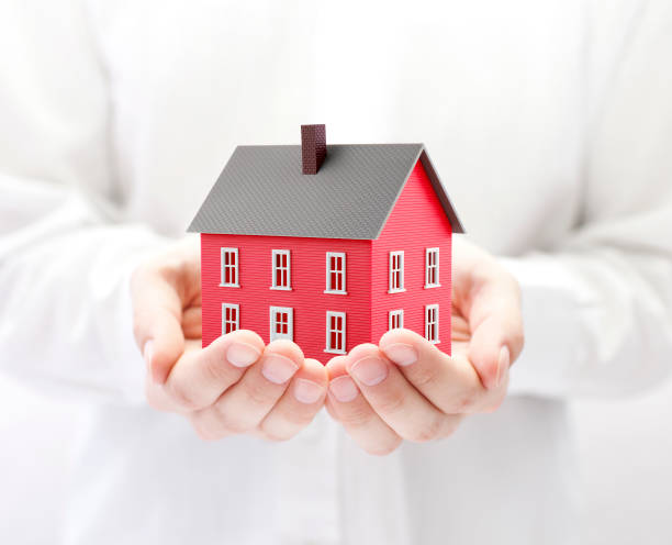 istock Small red toy house in hands 1171676093