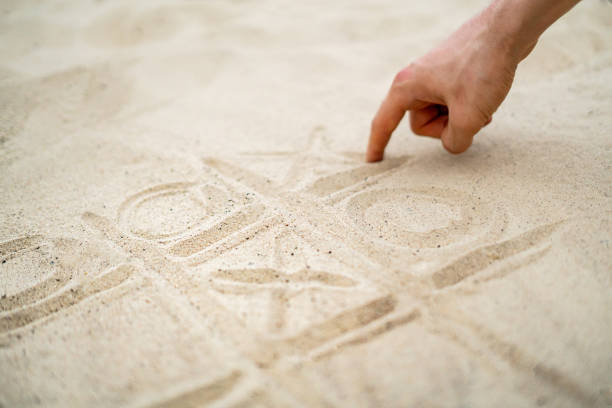 istock hand drawing tic tac toe playing on the sand in the summer beach 1171676265