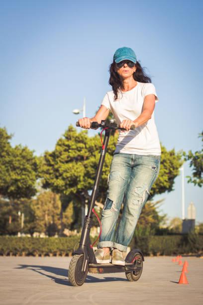 istock Woman, dressed in broken jeans, riding electric kick scooter 1171677840