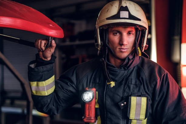 istock Portrait of a handsome fireman wearing a protective uniform with flashlight included standing in a fire station garage 1171678912