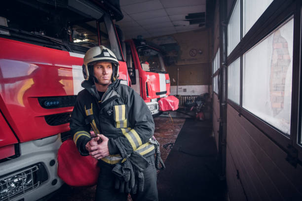 istock Young fireman wearing protective uniform standing next to a fire engine in a garage of a fire department 1171679716