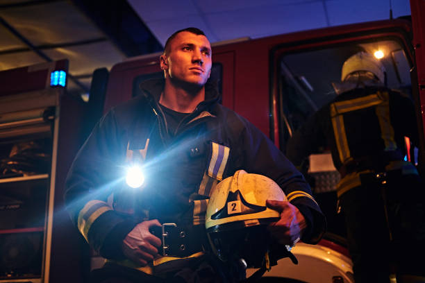 istock The fire brigade came to the call at night. Handsome fireman wearing a protective uniform with a flashlight included 1171679881