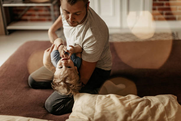 istock Father embracing his son in bed 1171681635
