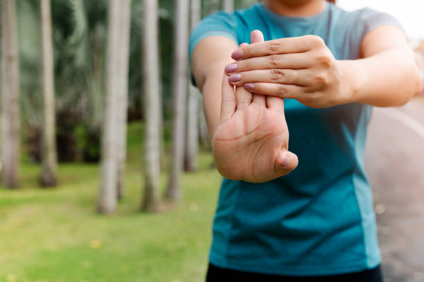 sport woman stretching forearm before exercising. outdoor sport and excercise activities concept stock photo