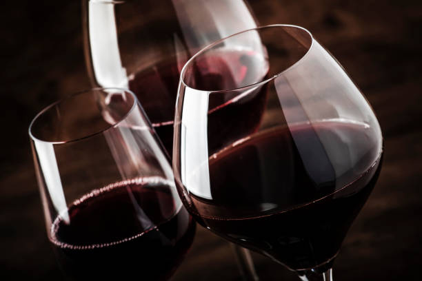 selezione di vino rosso in degustazione di vini. vini rossi secchi, semi-secchi e dolci in speciali bicchieri da vino su vecchio fondo da tavolo in legno. spazio di copia - red wine foto e immagini stock
