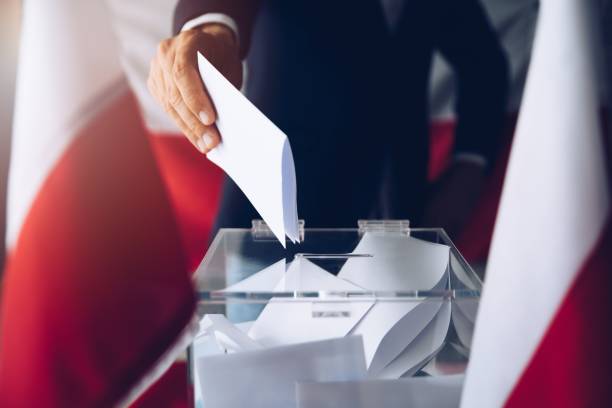 man putting his vote do ballot box. - polônia imagens e fotografias de stock