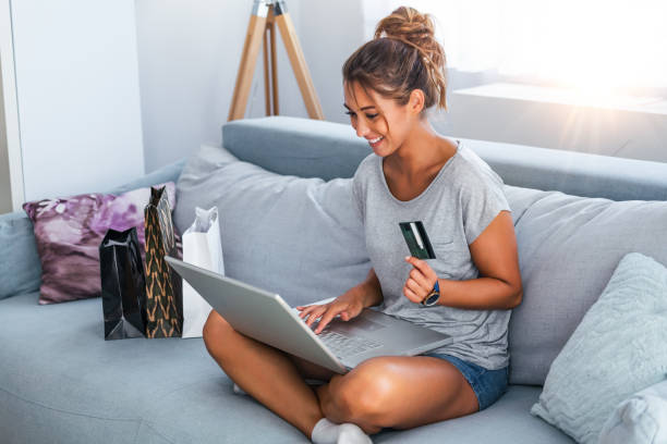 imagen que muestra la mujer bonita comprando en línea con tarjeta de crédito. mujer que tiene tarjeta de crédito y utiliza computadora portátil. concepto de compras en línea - e commerce women home shopping computer fotografías e imágenes de stock