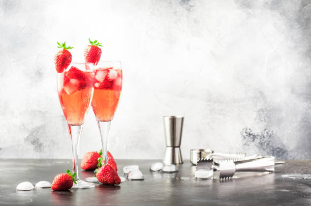rossini - cocktail alcolico italiano con spumante, purea di fragole fresche e ghiaccio in bicchieri di champagne, spazio di copia, messa a fuoco selettiva - champagne pink strawberry champaigne foto e immagini stock