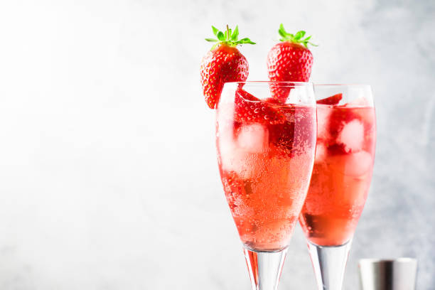 rossini - cocktail alcolico italiano con spumante, purea di fragole fresche e ghiaccio in bicchieri di champagne, spazio di copia, messa a fuoco selettiva - champagne pink strawberry champaigne foto e immagini stock