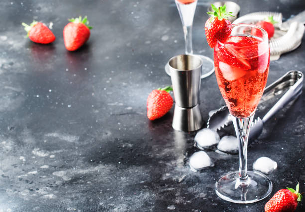 Rossini - italian alcoholic cocktail with sparkling wine, fresh strawberry puree and ice in champagne glasses, copy space, selective focus