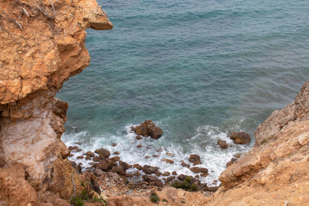 Exotic cliff rock, background sea Light brown color rocks and cliff, waves hitting the rocks lagün stock pictures, royalty-free photos & images