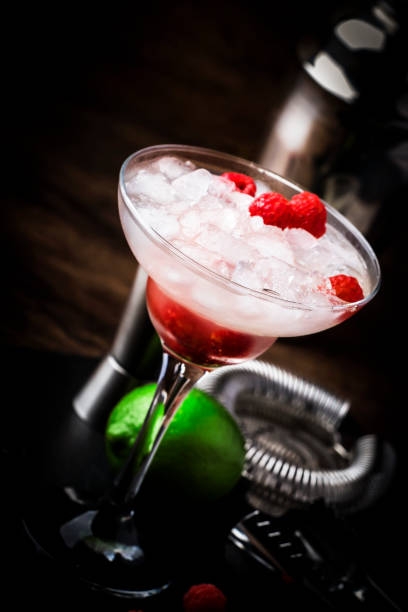 istock Raspberry daiquiri, alcoholic cocktail with white rum, lime juice, raspberries and crushed ice in tall glass, on wooden bar counter  with steel bar tools 1171685161
