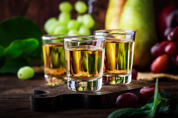 rakija, raki o rakia - bevanda alcolica dura balcanica o brandy da frutta fermentata, vecchio tavolo di legno, natura morta, spazio di copia - vodka hard liquor bottle palinka foto e immagini stock