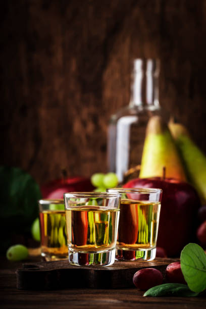 rakija, raki o rakia - bevanda alcolica dura balcanica o brandy da frutta fermentata, vecchio tavolo di legno, natura morta, spazio di copia - vodka hard liquor bottle palinka foto e immagini stock