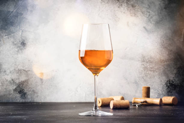 大きなワイングラスのオレンジワイン、ファッショナブルなモダンドリンク、グレーのカウンターの背景、コピースペース、選択的な焦点 - wine glass ストックフォトと画像