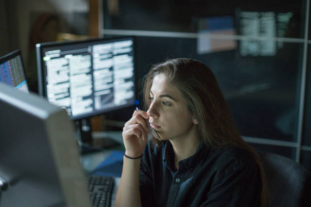 istock Woman monitors dark office 1171686910
