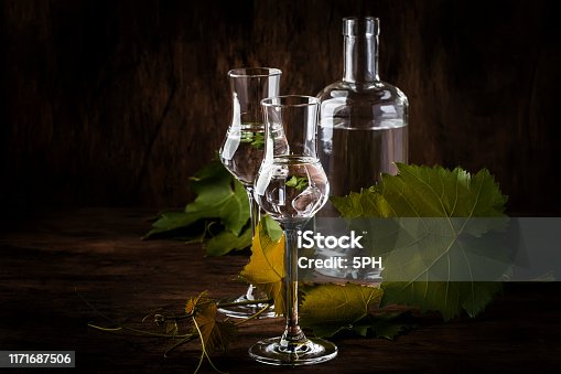 istock Grape vodka, pisco - traditional Peruvian strong alcoholic drink in elegant shot glasses on vintage wooden table, copy space 1171687506