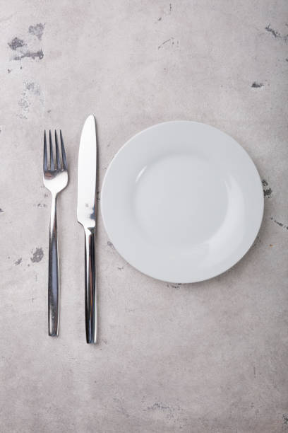 istock Metal forrk and knife with empty wite plate 1171688942