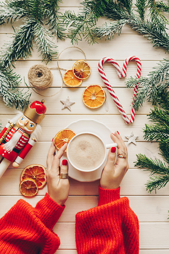 Woman in knitted sweater with mug of hot chocolate