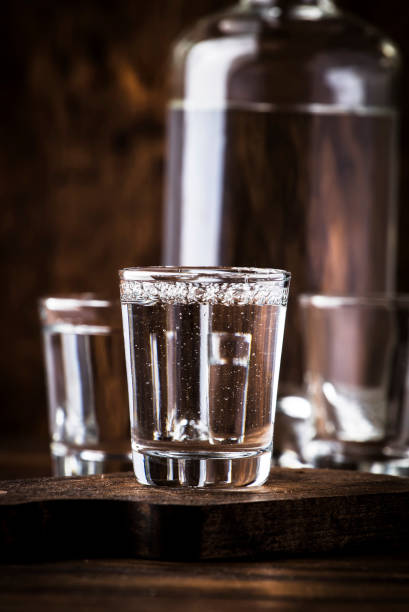 istock Cold vodka in shot glass, old wooden table, selective focus 1171691015