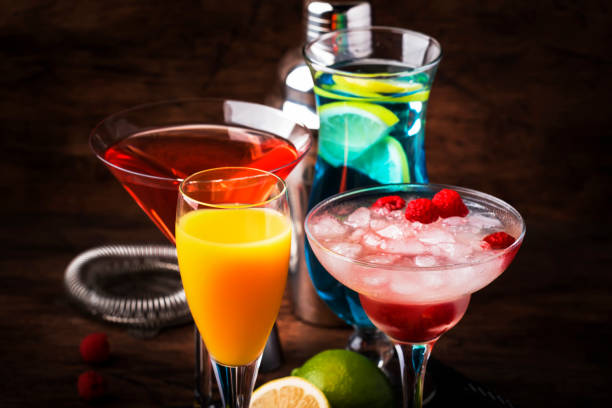 istock Colorful summer cocktails. Cold alcoholic beverages and drinks: mimosa, cosmopolitan, raspberry margarita and blue hawaii on wooden table background with bar tools 1171691061